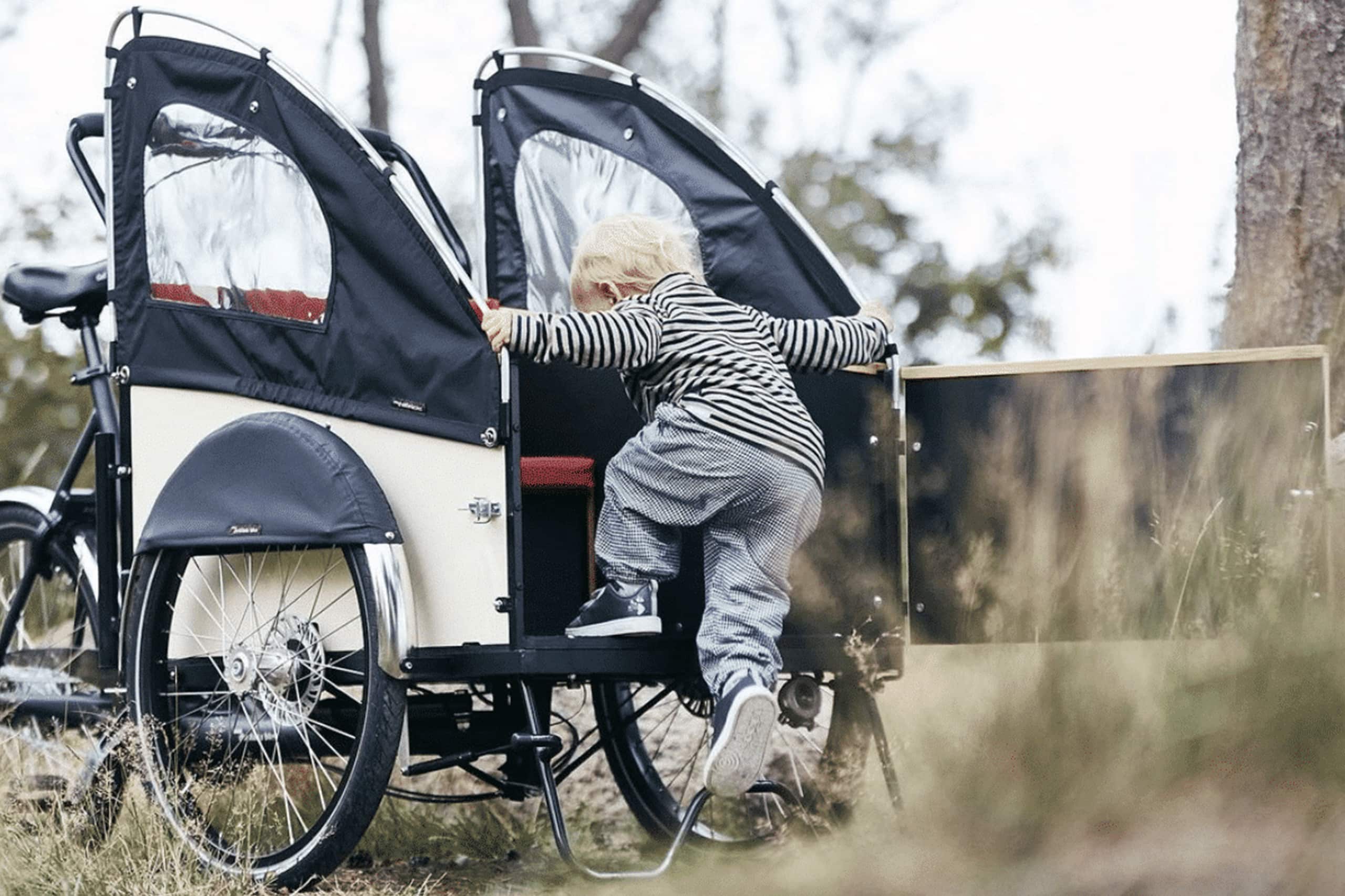 En lådcykel från Christiania Bikes med ett barn påväg in i "lådan"