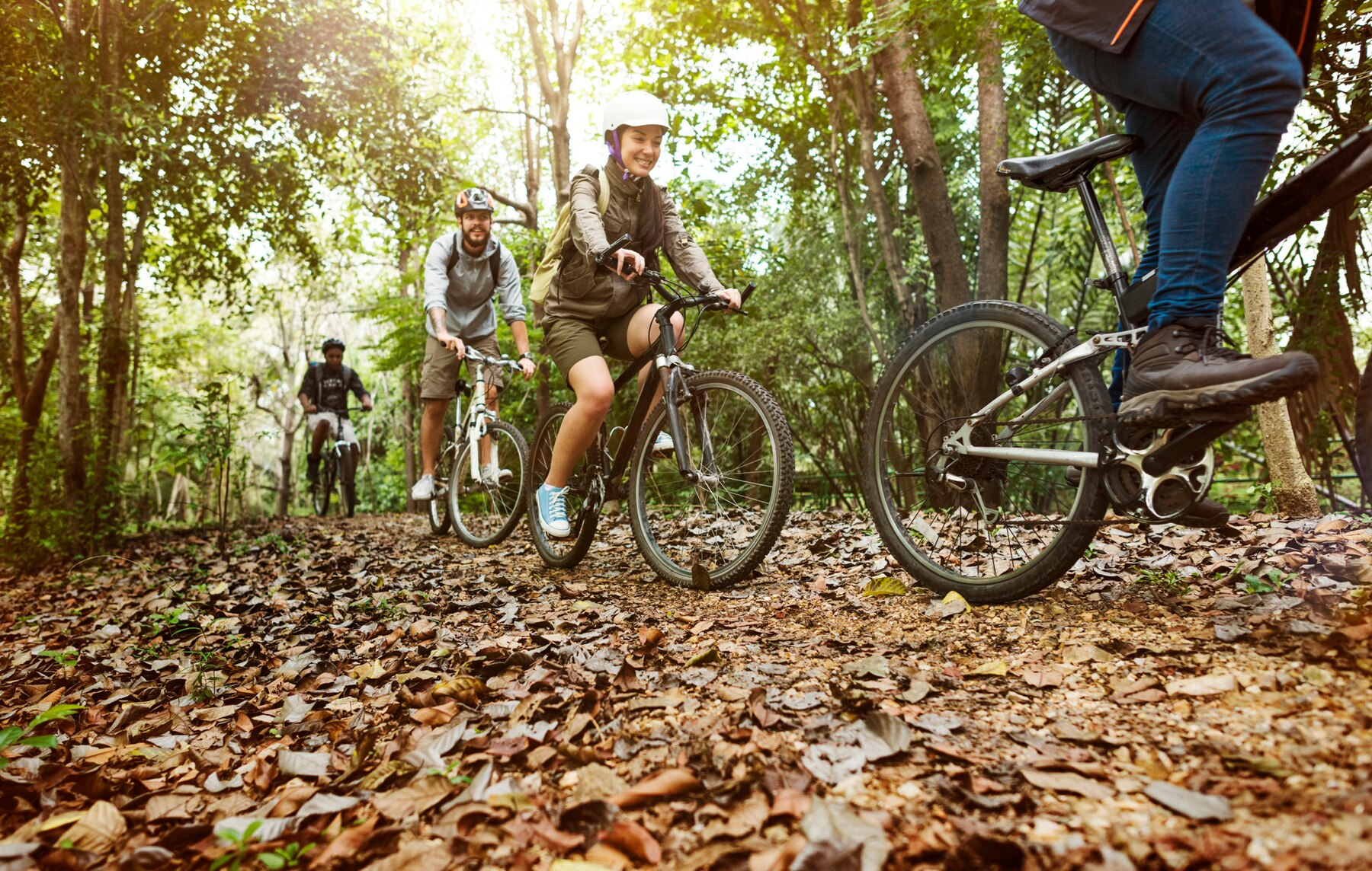 flera glada personer cyklandes pa en skogsvag